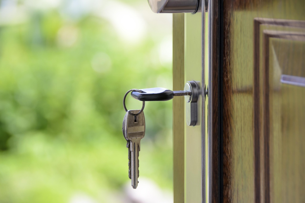 House key in the lock of an open front door.